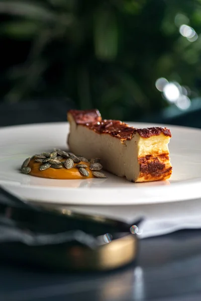 Piece of cheesecake on a plate.Basque cheesecake with sea buckthorn caramel. Photo of useful desserts.