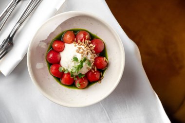 İtalyan mozzarella peyniri kiraz domatesli ve fesleğenli kiraz domatesli mozzarella mus ve yeşil tereyağlı.