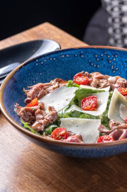 Biftek, roka ve sebzeli salata. Pişirilmiş. Kızarmış. Lezzetli. Restoranda servis edilen yemek, menü konsepti. Sağlıklı yiyecekler, kapatın.