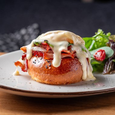 Benedict usulü yumurta, kızarmış İngiliz keki, jambon, haşlanmış yumurta ve lezzetli Hollandez sosu. Lezzetli. Restoranda servis edilen yemek, menü yemek konsepti..