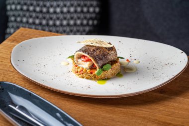 Beyaz kasede bulgur ve sebzeli alabalık. Sağlıklı yiyecekler, yakın plan. Restoranda yemek servisi.