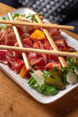 Şarap seti prosciutto, ventricina, bresaola ve Grissini ekmek çubukları. Geleneksel İtalyan antipatiği. Sağlıklı yiyecekler, yakın plan. Restoranda yemek servisi..