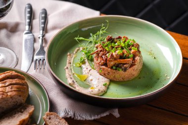 Mantarlı, mantarlı, mantarlı ve mantarlı kremalı tartar. Yemek yuvarlak bir seramik tabakta yatıyor. Tabakta yemek var. Restoran menüsü konsepti. Boşluğu kopyala.