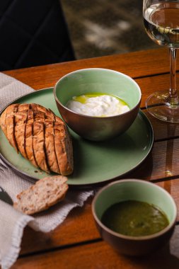 Stracciatella ve bruschetta. Krem peynirli çavdar ekmeği. Tabakta yemek var. Restoran menüsü konsepti. Boşluğu kopyala.