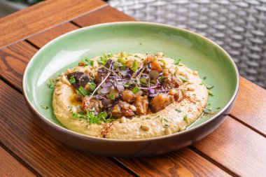 Hummus with warm eggplant in sweet chilli sauce. Healthy vegan food, Israeli cuisine. clipart