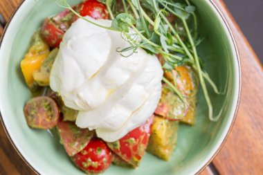 Kiraz domatesli Burrata salatası, soslu ve baharatlı bir kâse. Sağlıklı yemek, diyet öğle yemeği konsepti. diyet menüsü. Tabakta yemek var. Restoran menüsü konsepti. Boşluğu kopyala.