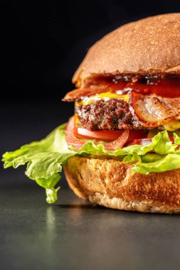Lezzetli hamburger bifteği ve pastırma, sandviç, fast food, lezzetli yemekler, siyah arka plana yakın çekim..