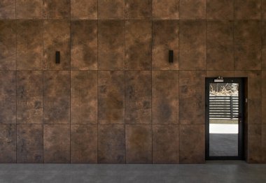 Modern kapıları, porselen taş kaplamaları olan modern bir binanın cephesi.