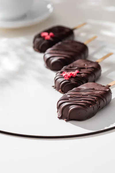 Köstliches Mit Schokolade Überzogenes Eis Stiel Vor Weißem Hintergrund lizenzfreie Stockfotos