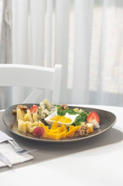 Farklı peynirli peynir tabağı ve beyaz arka planda meyveler. Parti için aperatif. Sağlıklı gıda konsepti. Bir restoranın arka planında