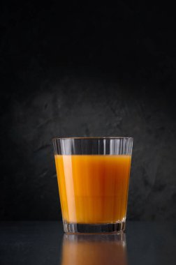 Bardakta çok meyveli meyve suyu. Yaratıcı minimalist kavram. Asgari yaratıcı gıda konsepti. Karanlık bir taş arka planda.