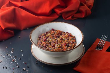 Gürcistan mutfağı. Mingrelian lobisi. Haşlanmış kırmızı fasulye aperatifi, koyu taştan bir arka planda soğan. Gürcü restoranı menüsü. Yaratıcı minimalist kavram. Yiyecek konsepti.