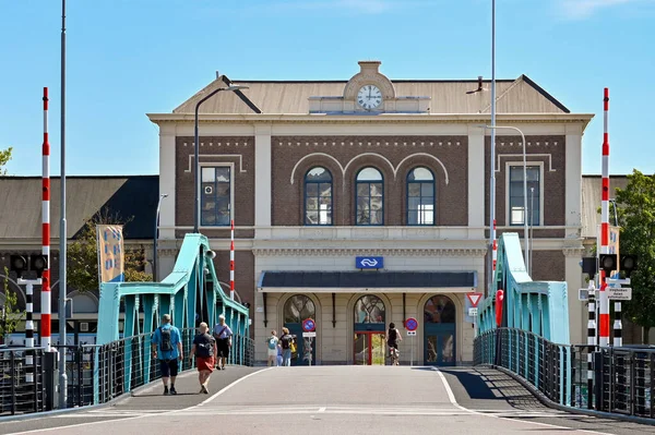 stock image Middleburg, Netherlands - August 2022: People walking over a bridge to the entrance of the city's railway station