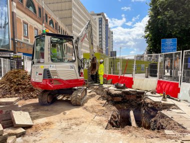 Cardiff, Wales - Mayıs 2022: Mini kazıcı şehir merkezinde bir iyileştirme planı üzerinde çalışıyor