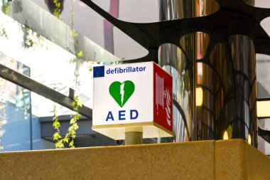 Amsterdam, Hollanda - Ağustos 2022: Kalp krizi geçiren hastaları tedavi etmek için acil durum defibrilatörünün yerini gösteren bir tren istasyonunu imzalayın