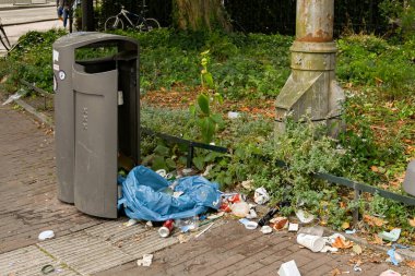 Amsterdam, Hollanda - Ağustos 2022: Şehir merkezine yakın bir sokakta çöp tenekesinin yanına atıldı