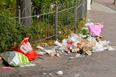 Amsterdam, Hollanda - Ağustos 2022: Şehir merkezine yakın bir sokakta çöp tenekesinin yanına atıldı