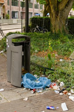 Amsterdam, Hollanda - Ağustos 2022: Şehir merkezine yakın bir sokakta çöp tenekesinin yanına atıldı
