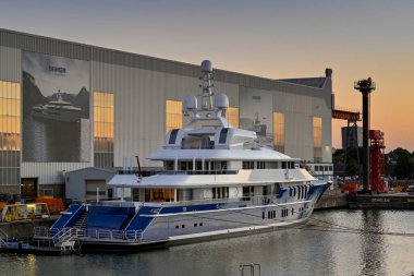 Vlissingen, Hollanda - Ağustos 2022: Günbatımında Damen yat fabrikasının önünde demirlemiş yeni lüks süper yat