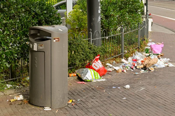 Amsterdam, Hollanda - Ağustos 2022: Şehir merkezine yakın bir sokakta çöp tenekesinin yanına atıldı