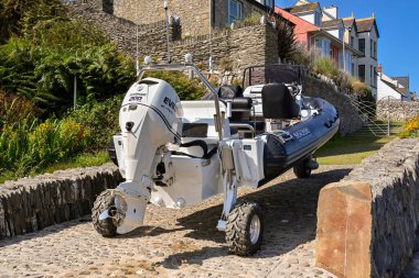 Newport, Pembrokeshire, Wales - August 2022: Rigid inflatable high speed motor dinghy with folding wheeels for transport on land clipart