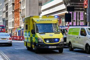 Londra, İngiltere, İngiltere - Haziran 2022: Londra şehir merkezindeki bir sokakta mavi ışıkları yanıp sönen acil ambulans