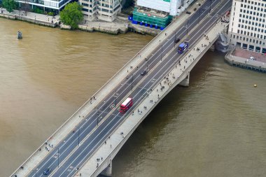 Londra, İngiltere - Ağustos 2021: Kırmızı çift katlı bir Londra otobüsünün ve Thames Nehri üzerinden geçen insanların hava görüntüsü