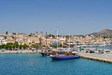 Aegina, Greece - May 2022: Tourist sightseeing boats moored alongside the quay on the town's waterfront clipart