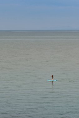 Newport, Pembrokeshire, Galler - Ağustos 2022: Denizdeki tek kürekçi