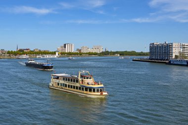 Rotterdam, Hollanda - Ağustos 2022: Rotterdam 'daki Nieuwe Maas nehri üzerinde sanayi mavnası ve turizm teknesi.
