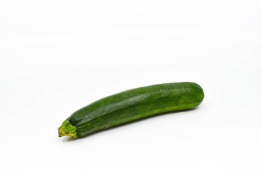 single courgette or zucchini on a plain white background. Copy space. No people.
