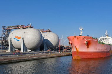 Antwerp, Belgium - August 2022: Large cargo ship Atlantic Journey docked in the city's port next to tanks of liquified gas