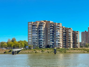 Rotterdam, Nertherlands - August 2022:  Apartment blocks on the riverbank of the Nieuwe Maas river.
