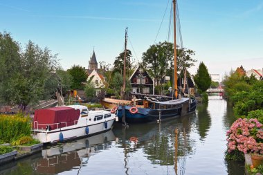 Edam, Netherlands - August 2022: Boats moored on one of the canals in the Dutch town of Edam, which is famous for its cheese.