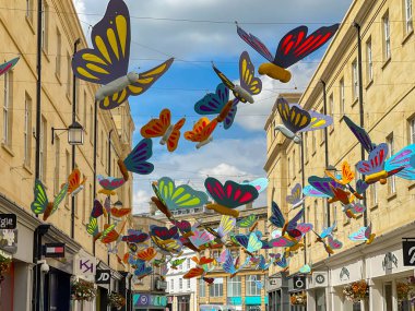Bath, Somerset, England - July 2022: Colourful hanging butterfly decorations over a city street to celebrate gay pride