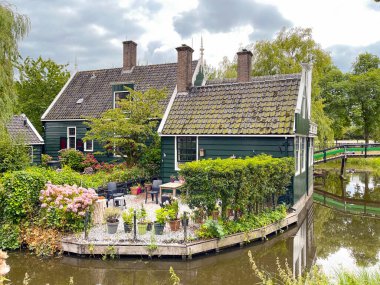 Edam, Netherlands - August 2022: Pretty wooden house alongside a canal near the centre of the town