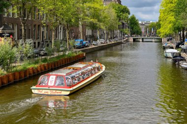 Amsterdam, Netherlands - August 2022: Tourist sightseeing boat sailing on one of the city's canals