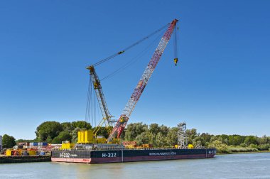 Rotterdam, Nertherlands - August 2022:  Industrial barge with heavy lifting crane moored on the Nieuwe Maas river.