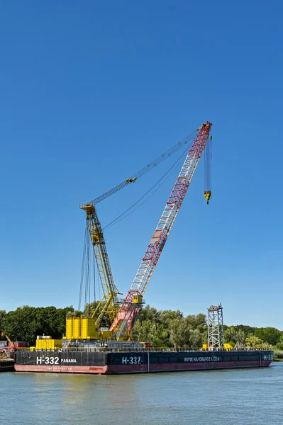 Rotterdam, Nertherlands - August 2022:  Industrial barge with heavy lifting crane moored on the Nieuwe Maas river.