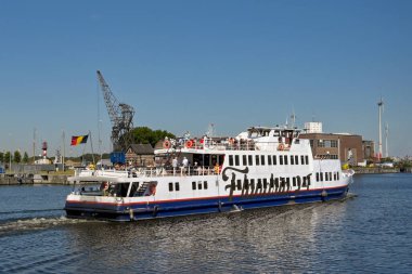 Antwerp, Belgium - August 2022: Passenger ferry with people on deck leaving the city's port