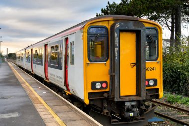 Rhoose, Wales - November 2022: Train about to leave Rhoose railway station at sunset. The train is operated by Transport for Wales.