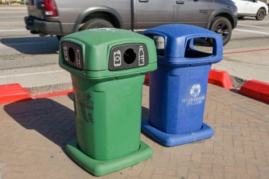 Galveston, Teksas, ABD - Şubat 2023: Galveston 'daki deniz kenarında geri dönüşüm malzemeleri ve çöpler için renkli plastik kutular.