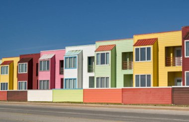Galveston, Teksas, ABD - Şubat 2023: Galveston 'un kıyı şeridinde pastel gölgeli parlak renkli tatil daireleri sırası
