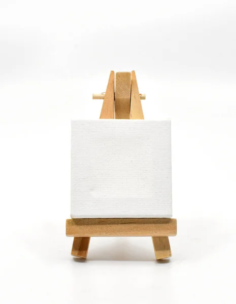 stock image Small wooden model easel with a blank art canvas resting on it isolated on a plain white background. Copy space, No perople.