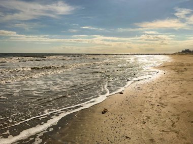 Galveston, Teksas 'ta, akşam güneşinde gelen gelgitin kıyısında. Kimse yok..