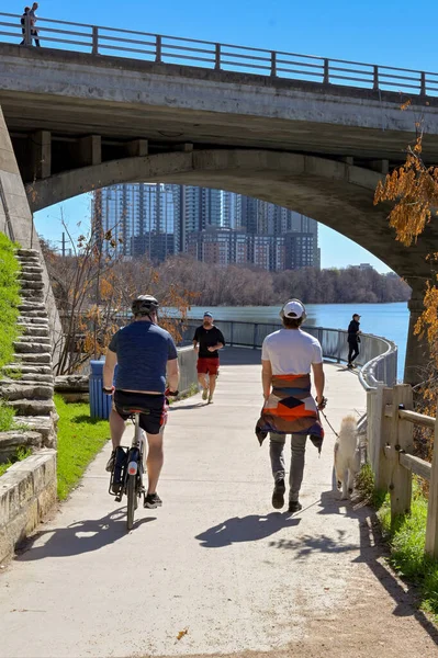 stock image Austin, Texas, USA - February 2023: People walking and cycling on the path alongside the river near the city centre