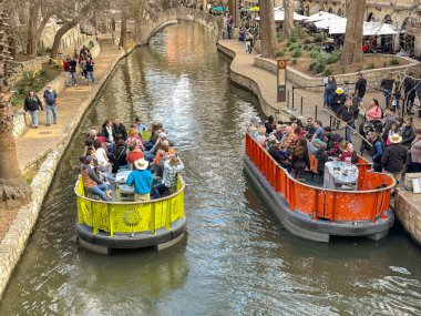 San Antonio, Teksas, ABD - Şubat 2023: Şehir merkezinden geçen nehir teknelerinde ziyaretçiler