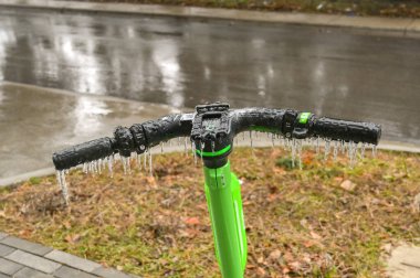 Austin, Teksas, ABD - Şubat 2023: Şehre dondurucu yağmurun düşmesinden sonra bir motorun gidonundan sarkan buz saçakları