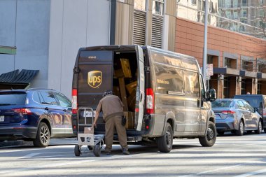 Austin, Teksas, ABD - Şubat 2023: Şehir merkezinde bir kargo minibüsünden paketleri boşaltan kişi