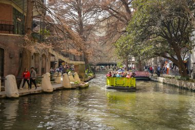 San Antonio, Teksas, ABD - Şubat 2023: Şehir merkezinden geçen nehir teknelerinden birinde ziyaretçiler